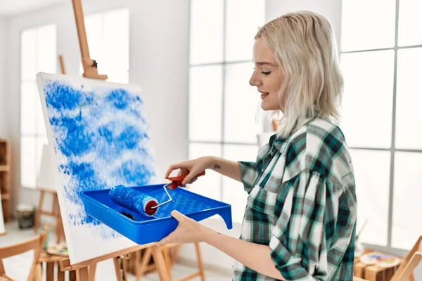 在艺术工作室里 年轻的艺术家学生女孩用彩绘滚筒微笑着作画 — 图库照片