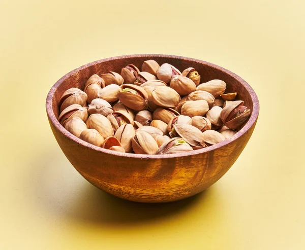  Sarı arka planda bir kase fıstık.