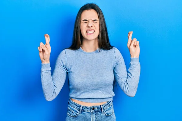 Young Brunette Teenager Wearing Casual Sweater Gesturing Finger Crossed Smiling — Fotografia de Stock