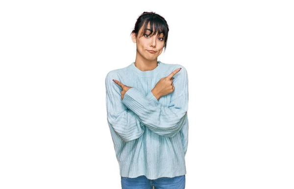 若いヒスパニック系の女性が指で両側を指してカジュアルな服を着て 異なる方向に同意しない — ストック写真