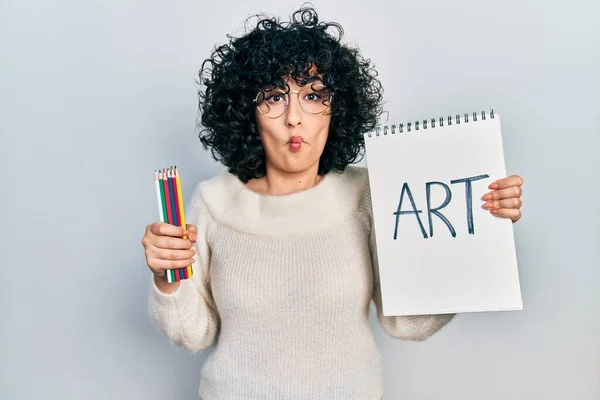 Young Middle East Woman Holding Art Notebook Making Fish Face — Foto Stock