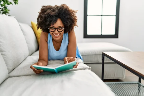 Νεαρή Αφροαμερικάνα Γυναίκα Χαμογελά Αυτοπεποίθηση Βιβλίο Ανάγνωσης Στο Σπίτι — Φωτογραφία Αρχείου