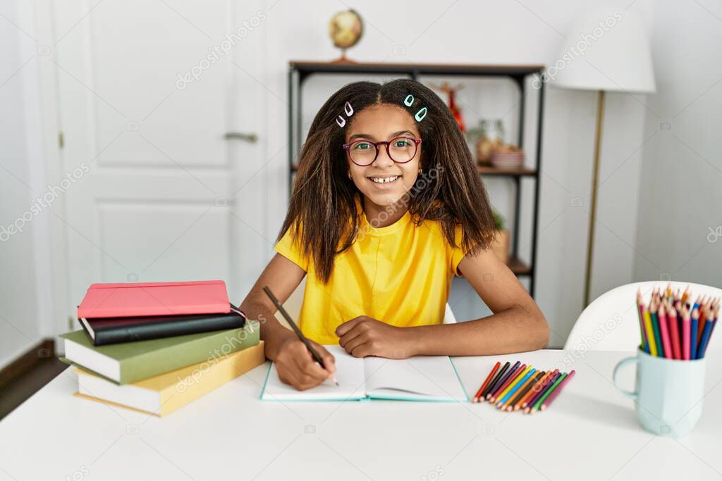 African american girl smiling confident doing school homework at home