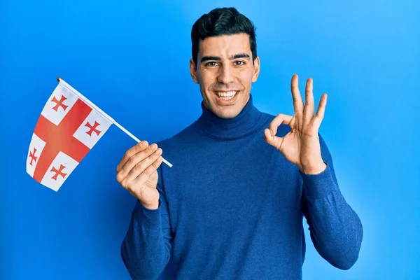 Snygg Latinamerikansk Man Håller Georgia Flagga Gör Tecken Med Fingrar — Stockfoto
