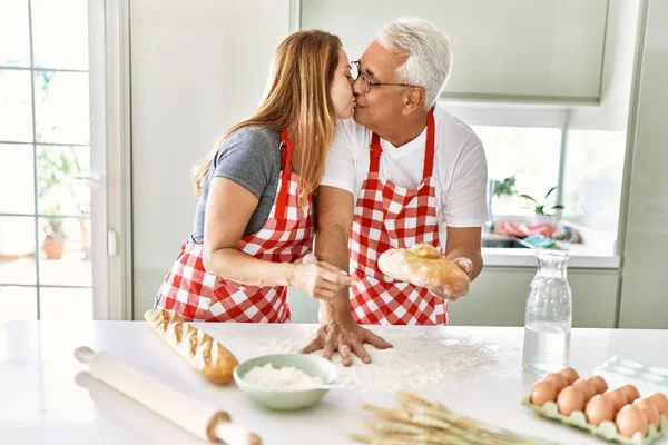 Middle Age Hispanic Couple Kising Cooking Bread Kitchen — Stock fotografie