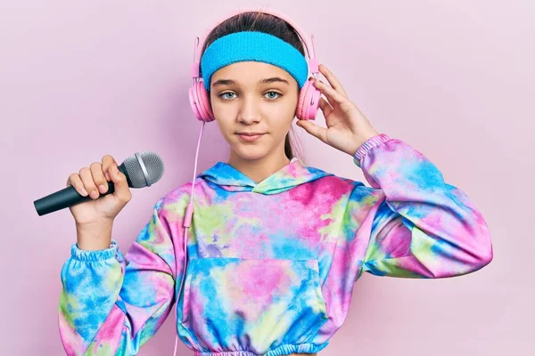 Young Brunette Girl Singing Song Using Microphone Wearing Sportswear Relaxed —  Fotos de Stock