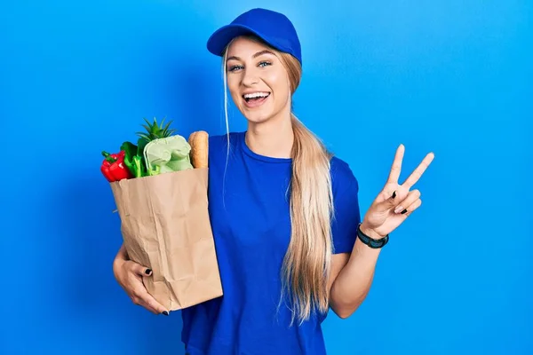 Junge Kaukasische Frau Kurieruniform Mit Lebensmitteln Aus Dem Supermarkt Lächelt — Stockfoto