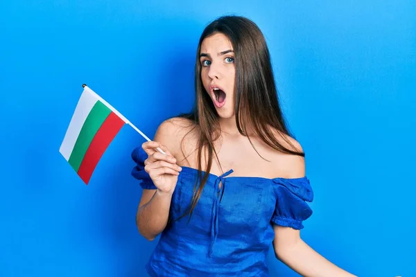 Young Brunette Teenager Holding Bulgaria Flag Scared Amazed Open Mouth — Fotografia de Stock