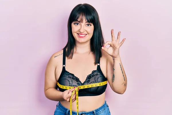 Young Hispanic Woman Using Tape Measure Measuring Breast Doing Sign — Foto de Stock