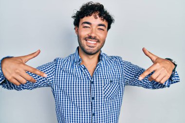 Günlük kıyafetler giyen, kendine güveni olan, kendini gururlu ve mutlu gösteren genç İspanyol bir adam.. 