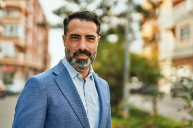 Orta yaşlı işadamı şehirde mutlu mesut dikilirken.