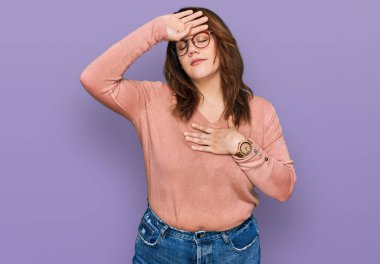 Young plus size woman wearing casual clothes and glasses touching forehead for illness and fever, flu and cold, virus sick 