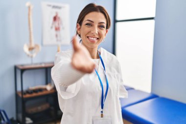 Genç esmer kadın ağrı kesici kliniğinde çalışıyor. Gülümsüyor, avuç içi kadar yardım ve kabul görüyor.. 