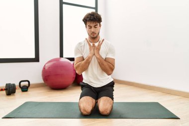 Genç İspanyol adam spor merkezinde yoga eğitimi alıyor.
