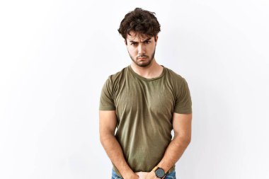 Hispanik adam izole edilmiş beyaz arka planda duruyor şüpheci ve gergin, sorun yüzünden surat asıyor. negatif kişi. 