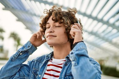 Şehirde kulaklık takıp müzik dinleyen genç bir İspanyol.