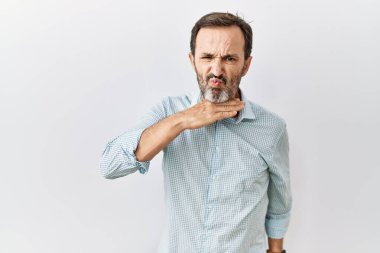 Middle age hispanic man with beard standing over isolated background cutting throat with hand as knife, threaten aggression with furious violence 