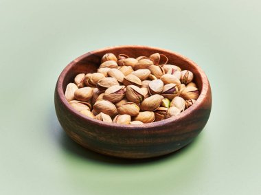  Yeşil arka planda bir kase şam fıstığı