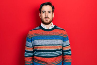 Sakallı, zarif yün kazak giyen yakışıklı beyaz adam yüzünde ciddi bir ifadeyle rahatlamış. Basit ve doğal bir şekilde kameraya bakıyorsun.. 