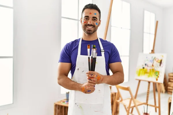 Young Hispanic Man Smiling Confident Holding Paintbrushes Art Studio — ストック写真