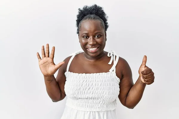 自信と幸せ笑いながら指の数6を示し 指差す白い孤立した背景の上に立っている若いアフリカの女性 — ストック写真