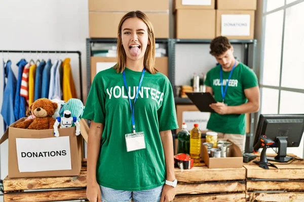 Menina Loira Jovem Vestindo Shirt Voluntária Carrinho Doação Colando Língua — Fotografia de Stock