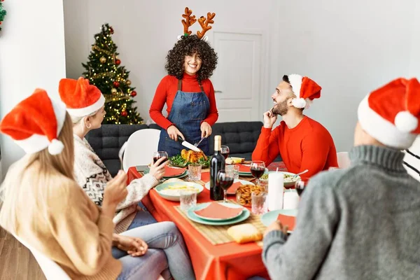 Ομάδα Νέων Ανθρώπων Χαμογελώντας Ευτυχείς Έχοντας Χριστουγεννιάτικο Δείπνο Γυναίκα Κοπή — Φωτογραφία Αρχείου