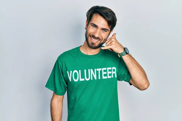 Jovem Hispânico Vestindo Camiseta Voluntária Sorrindo Fazendo Gesto Telefônico Com — Fotografia de Stock