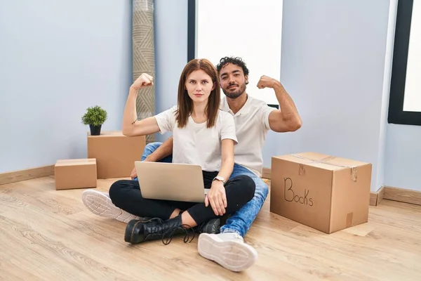 Casal Jovem Usando Laptop Nova Casa Forte Pessoa Mostrando Músculo — Fotografia de Stock