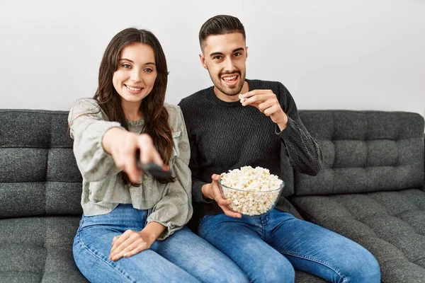 Unga Latinamerikanska Par Tittar Film Och Äter Popcorn Sittandes Soffan — Stockfoto