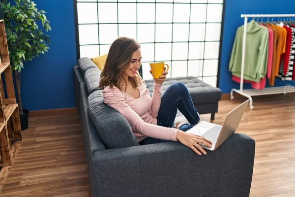 Młoda Kobieta Używa Laptopa Pije Kawę Siedząc Kanapie Domu — Zdjęcie stockowe