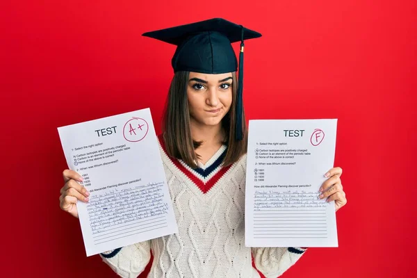 問題のために動揺を眉をひそめて 懐疑的で緊張した試験を示す卒業キャップを身に着けている若いブルネットの女の子 否定的な人 — ストック写真