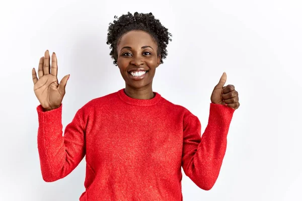 自信を持って幸せな笑顔ながら 孤立した背景の上にカジュアルな服を身に着けている若いアフリカ系アメリカ人の女性は 指の数6を示すと指摘 — ストック写真