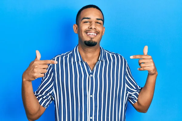 아프리카 미국인 남자가 평상복을 얼굴에 미소를 머금은 자랑스럽고 손가락으로 자신을 — 스톡 사진
