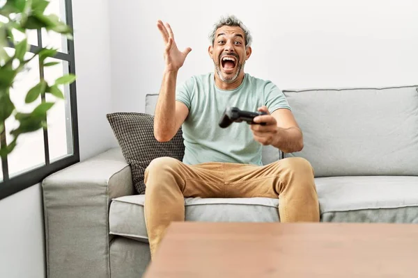 Middle Age Hispanic Man Playing Video Game Sitting Sofa Celebrating — Stock Photo, Image