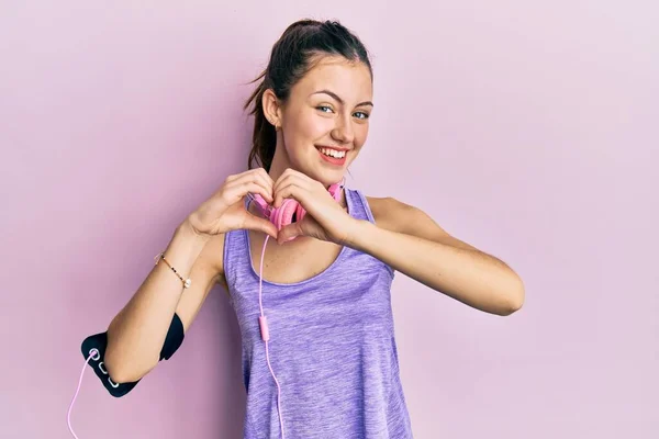 Jonge Brunette Vrouw Draagt Sportkleding Hoofdtelefoon Glimlachend Liefde Doen Hart — Stockfoto