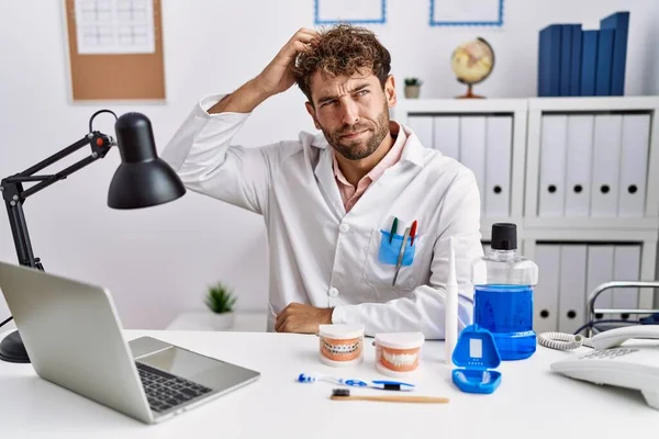 Young Hispanic Dentist Man Working Medical Clinic Confuse Wonder Question — Stock Photo, Image