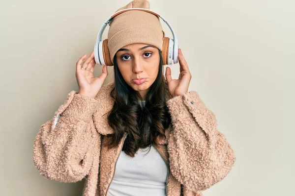 若いヒスパニック系の女性は ヘッドフォンを使用して音楽に耳を傾け落ち込んで苦痛のために心配し 怒っていると恐れている 悲しい表情 — ストック写真