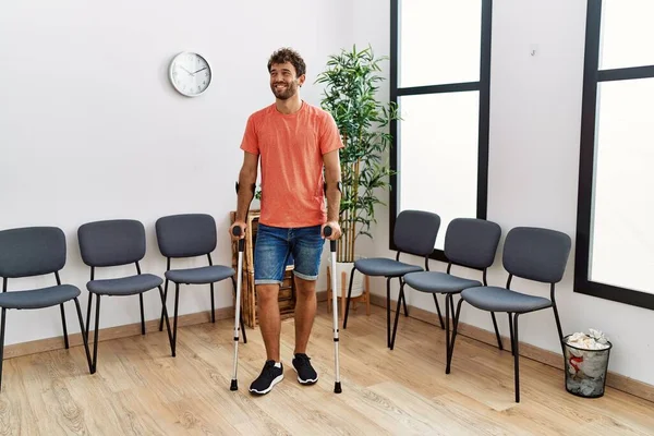 Klinik Bekleme Odasında Koltuk Değneği Kullanarak Yürüyen Genç Bir Spanyol — Stok fotoğraf