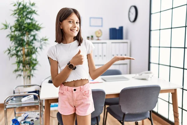 Young Hispanic Girl Standing Pediatrician Clinic Showing Palm Hand Doing — Stock fotografie