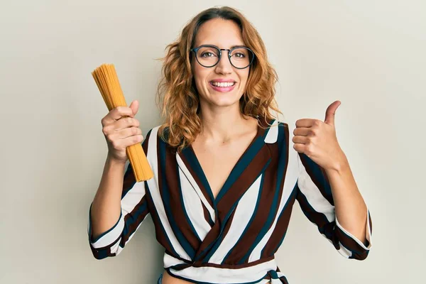 Ung Kaukasisk Kvinna Håller Okokt Spaghetti Pasta Ler Glad Och — Stockfoto