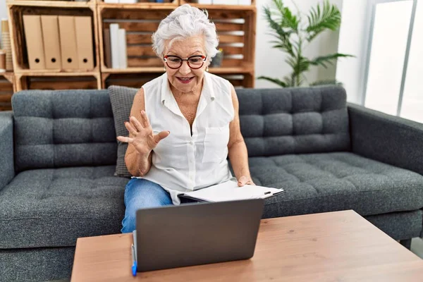 在咨询处工作的白发苍苍的老年妇女正在做在线治疗 她面带微笑 面带微笑 面带微笑 看上去很积极 很快乐 — 图库照片