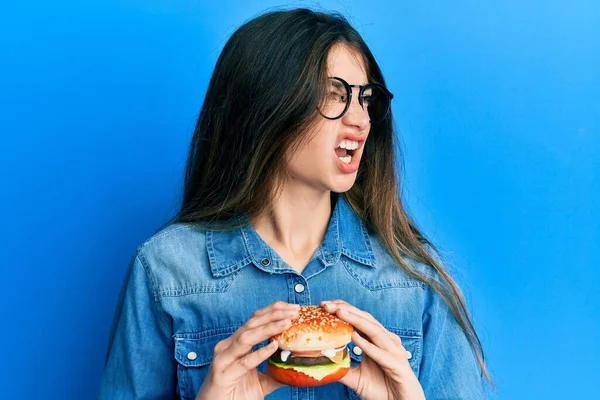 Young Caucasian Woman Eating Tasty Classic Burger Angry Mad Screaming — Stock Photo, Image