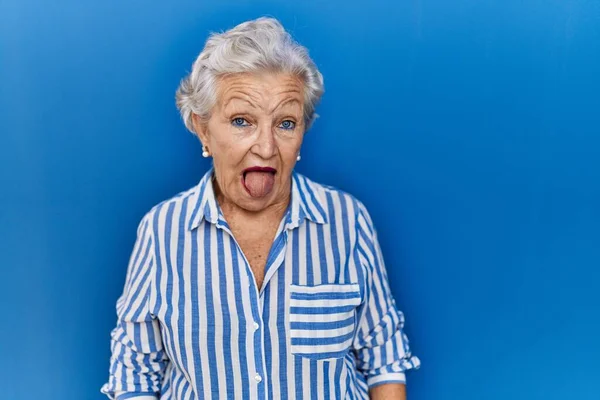 Senior Woman Grey Hair Standing Blue Background Sticking Tongue Out — Stock Photo, Image