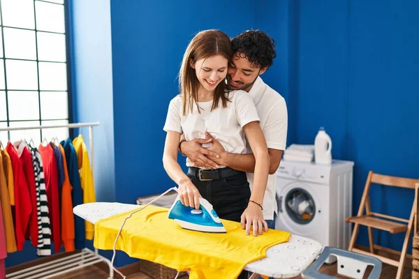 男女カップル抱擁お互いにアイロンで洗濯室 — ストック写真