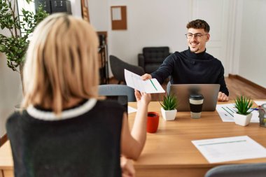 Ofiste dizüstü bilgisayarla çalışırken gülümseyen iki iş adamı..