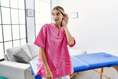 Genç sarışın kadın evde fizyoterapist olarak çalışıyor. Kulaktan kulağa gülümsüyor. Dedikoduları ve dedikoduları dinliyor. Sağırlık kavramı. 