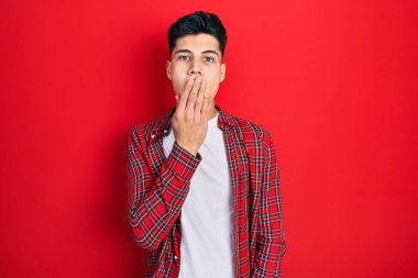 Gündelik kıyafetler giyen genç İspanyol adam ağzıyla ağzını kapatmaktan sıkılmış. Huzursuz ve uykulu.. 