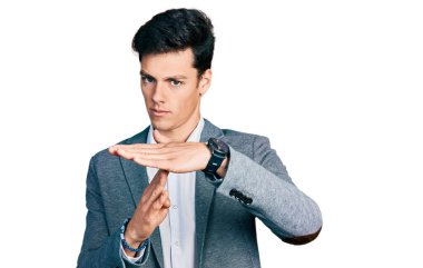 İş kıyafetleri giymiş genç İspanyol bir adam. El kol hareketleri yapıyor. Hayal kırıklığına uğramış ve ciddi bir yüz ifadesi takınıyor. 