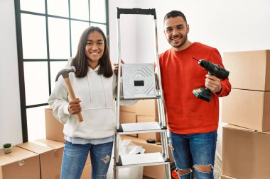 Genç latin çift gülümsüyor mutlu mesut yeni evlerini onarıyorlar.